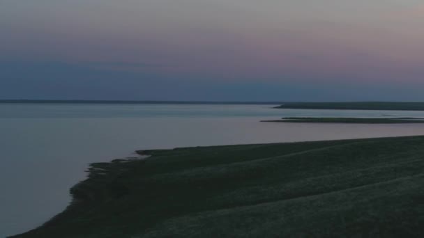 Вид с воздуха на красивое изумрудно-зеленое озеро и летний пейзаж заката. Закат на озере — стоковое видео
