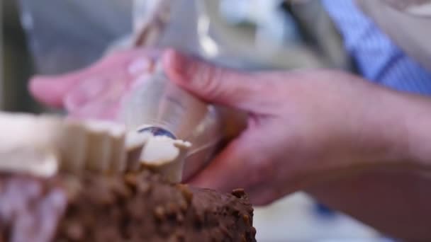 Baka en tårta. Klämma grädden på moset. Läckra smaskiga krämen pressas på kakan — Stockvideo