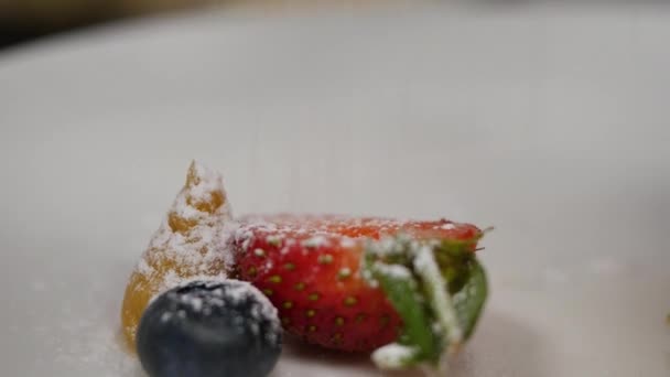 Fresas y arándanos con espolvoreos de azúcar en polvo. Espolvoreo de polvo sobre las fresas arándanos — Vídeos de Stock