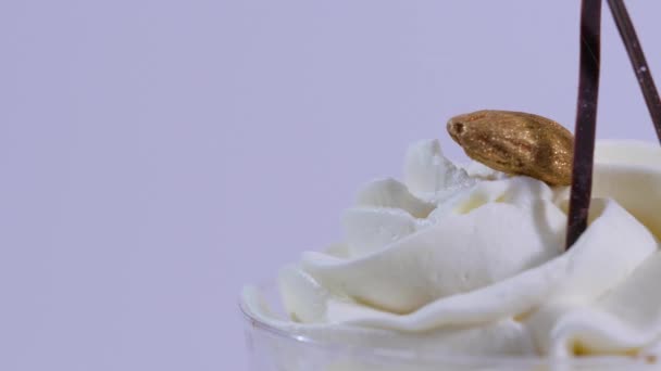 Gelato alla vaniglia in coppa su sfondo. Gelato in un bicchiere con crema, primo piano — Video Stock
