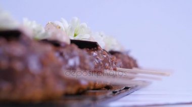 Dondurma, çikolata ile kaplı. Çikolatalı dondurma bir sopa. Çikolatalı dondurma çiçeklerle süslenmiş bir sopa