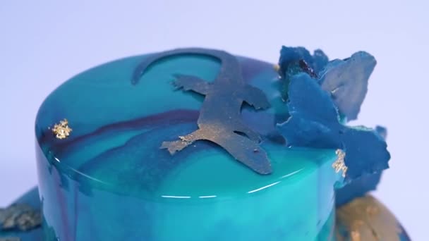 Мус торт оформлений у морському стилі покриті дзеркало синій глазур'ю і Білий шоколад черепашки. Європейська французький десерт. — стокове відео