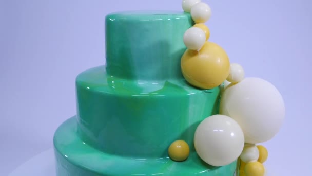 Stylish mousse cake with turquoise mirror glaze. Cake with turquoise mirror glaze decorated with chocolate balls — Stock Video