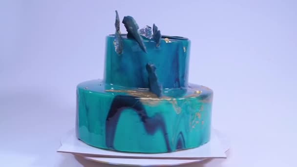 Mousse cake decorated in marine style covered with blue mirror glaze and white chocolate seashells. European french dessert. — Stock Video