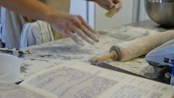 Detail of womans hand rolling out a dough with a rolling pin while making homemade pasta. Womans hands rolling dough — Stock Video