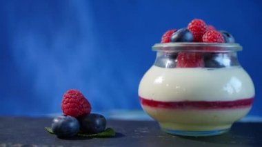 Ev yapımı yoğurt bir cam kavanoza yaban mersini ile. Çilekli yoğurt, yakın çekim.