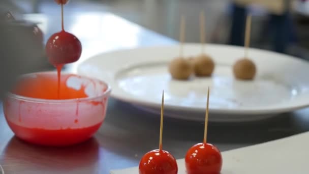 Femme trempant des bonbons pomme dans un bol avec du caramel . — Video