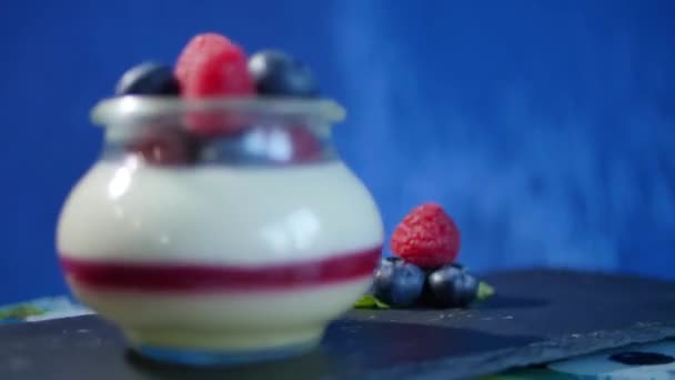Homemade yogurt with blueberries in a glass jar. Strawberry in Yogurt, close up. — Stock Video