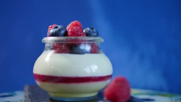 Zelfgemaakte yoghurt met bosbessen in een glazen pot. Aardbei in yoghurt, close-up. — Stockvideo