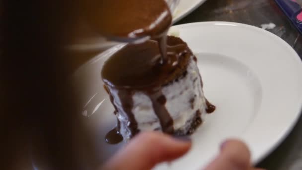 Chocolade siroop wordt uitgegoten over een cake, chocolade fudge op taart topping — Stockvideo