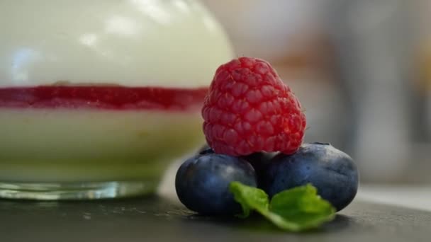 Yogurt fatto in casa con mirtilli in un barattolo di vetro. bacche ben organizzate per decorare il dessert, da vicino . — Video Stock
