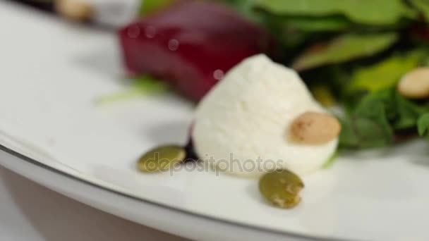 Frischer Salat mit Obst und Gemüse auf weißem Holzhintergrund mit Platz für Text. Gesunde Ernährung. Salat mit Käse und frischem Gemüse isoliert auf weißem Hintergrund. griechischer Salat — Stockvideo