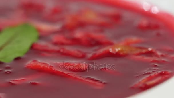 Ukrainian and russian national food - red beet soup borscht with beef.Moldovan soup. Close up. plate of beetroot cream soup on checkered dishtowel. Russian national food, red beet soup, borscht — Stock Video