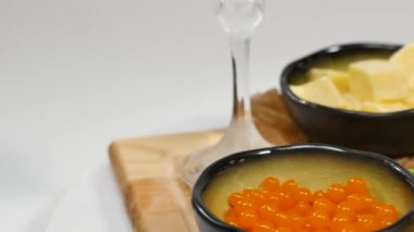 Doğranmış tereyağı, havyar, siyah ekmek. Kaşık ile kırmızı havyar kase dilimlenmiş ekmek, tereyağı ve otlar beyaz arka plan üzerinde hizmet verdi. Kepekli ekmek, tereyağı ve kırmızı havyar, beyaz arka plan