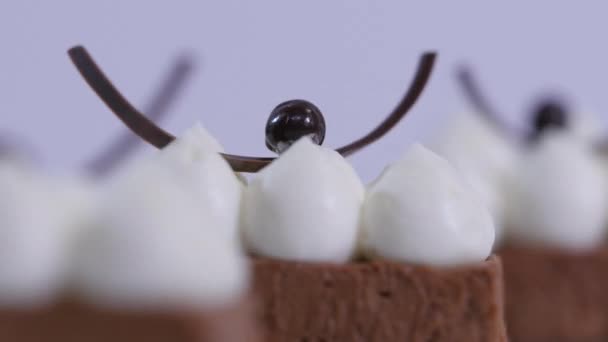 Un pastel de chocolate en un plato blanco con crema batida. Postre mousse de chocolate con crema batida de cerca — Vídeos de Stock