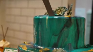 Pasta şefi pasta uzun bir bıçak ile kesmek. Turkuaz bir pasta kesti. Pasta şefi pasta kesme