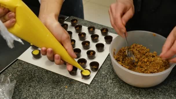 Großaufnahme Köche Hände dekorieren Schokolade mit Sahne und Nüssen. Frauen bereiten Süßigkeiten mit Sahne und Nüssen zu — Stockvideo