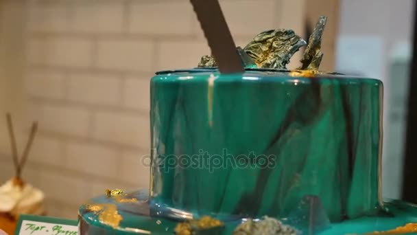 De chef van het gebakje snijden de taart met een lang mes. Het snijden van een turquoise taart. De chef van het gebakje snijden de taart — Stockvideo