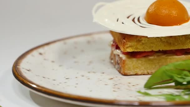 Victoria sponge cake with straberries, jam and whipped cream with a cut out piece on a white background — Stock Video