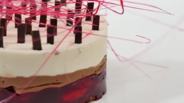 Bolo de creme com três camadas em uma chapa. Bolo de creme com três camadas, decorado com migalhas de chocolate e palha de chocolate — Vídeo de Stock