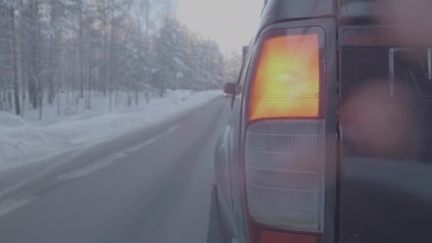 Lâmpada traseira SUV na estrada de inverno, luz vermelha. Fechar o carro preto grande da vista traseira em uma estrada de inverno — Vídeo de Stock
