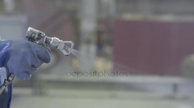Endüstriyel boyutu sprey boyama ve kaplama sanayi için kullanılan silah tutan el kol. Erkek el boya sprey, closeup tutarak