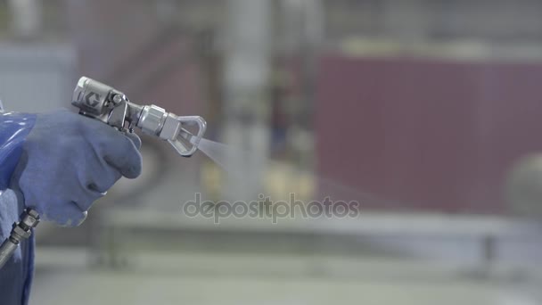 Braço mão segurando tamanho industrial pistola de pulverização usada para pintura industrial e revestimento. Mão masculina segurando spray de tinta, close-up — Vídeo de Stock