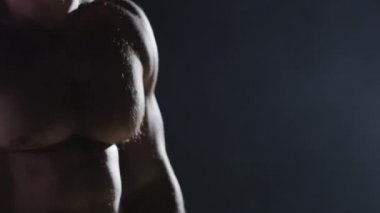 Savaşçı siluet. Yakışıklı atletik adam boks standında karanlık bir arka plan üzerinde. Kas genç adam boks eldivenleri ve şort farklı hareketleri ve grevler gösterir