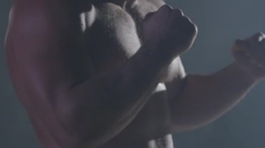 Savaşçı siluet. Yakışıklı atletik adam boks standında karanlık bir arka plan üzerinde. Kas genç adam boks eldivenleri ve şort farklı hareketleri ve grevler gösterir