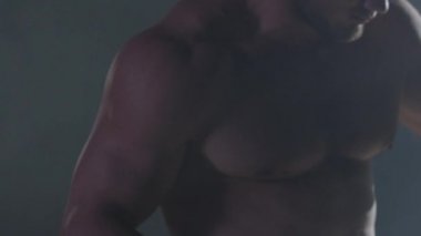 Savaşçı siluet. Yakışıklı atletik adam boks standında karanlık bir arka plan üzerinde. Kas genç adam boks eldivenleri ve şort farklı hareketleri ve grevler gösterir