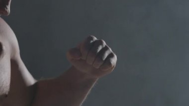Yumruklar duman koyu arka planda kapatın. Kas kickbox veya muay Tay savaşçı duman Delme.