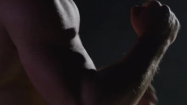 Savaşçı siluet. Yakışıklı atletik adam boks standında karanlık bir arka plan üzerinde. Kas genç adam boks eldivenleri ve şort farklı hareketleri ve grevler gösterir