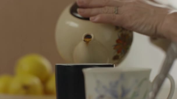 Womans mano verter el té de la tetera en el vaso — Vídeos de Stock