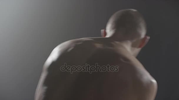 Man trainig ombra boxe al buio con fumo vista posteriore. Un bel pugile muscoloso. Silhouette di pugile uomo senza guanti da boxe su sfondo nero vista posteriore — Video Stock