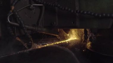 Kaynakçı ile kişisel koruyucu ekipman tam olduğunu gerçekleştirmek otomatik kaynak sistemi kullanarak karanlık bölgede boru kaynak. Kaynak her yere yayılan kıvılcım. Otomat kaynak boru üretimi