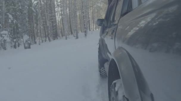 Jeep cabalga sobre la nieve en el primer plano del bosque. Cronograma — Vídeo de stock