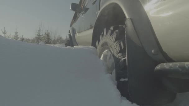 Вождение внедорожника зимой по лесной дороге с большим количеством снега. Машина застряла в лесу. Крупный план — стоковое видео