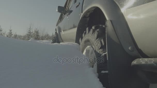 Conducir SUV coche en invierno en carretera forestal con mucha nieve. Coche atrapado en el bosque. Primer plano. — Vídeo de stock