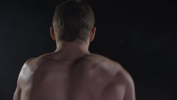 Děrování. Svalnatý muž boxu na černém pozadí. Boxer cvičí shadow box — Stock video