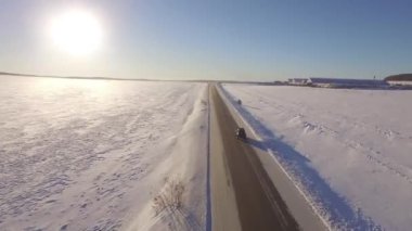 SUV ile karlı alan yolda gidiyor. Havadan görünümü bir karlı alan ve quadrocopter yoldan. Karlı alanları ve yol havadan görünümü