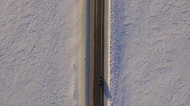 SUV ile karlı alan yolda gidiyor. Havadan görünümü bir karlı alan ve quadrocopter yoldan. Karlı alanları ve yol havadan görünümü