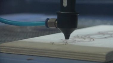 Lazer el feneri bir kontrplak tabak kesiyor. Lazer kesim ışını kontrplak levha üzerine