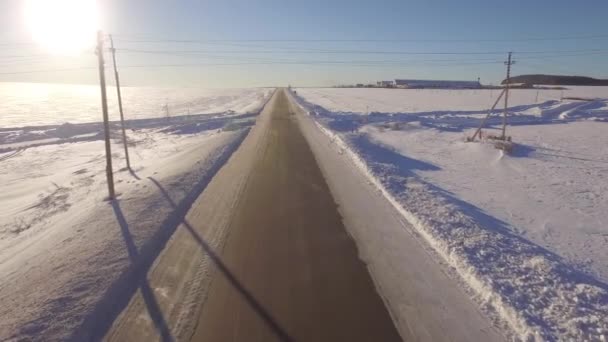 Légi utak. Vezetés a fehér havas örökzöld erdő csúszós aszfaltúton SUV. A légi felvétel a az út és a mező, a téli — Stock videók