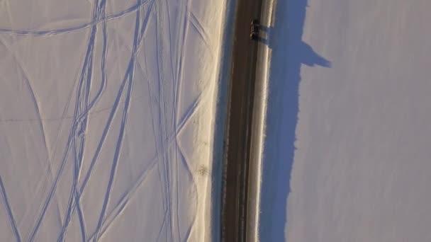 Widok z lotu ptaka na snowy pole i drogi. Samochód na drodze w tundrze, widok z góry — Wideo stockowe