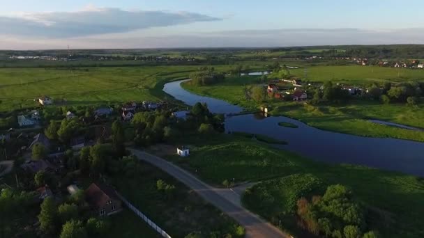 小さな村の arial 景色は。川と緑の牧草地の表示 — ストック動画