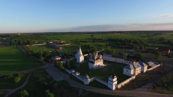 Letecký pohled shora církve a zelených polí za slunečného dne — Stock video