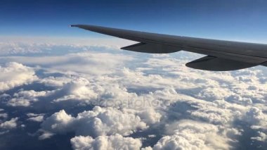Bulutların üzerinde uçan bir uçağın kanat. Seyahat için hava taşımacılığı kullanarak uçak penceresinden gökyüzü insanlar bakmak