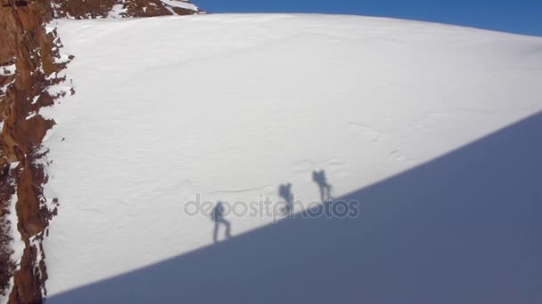 Alpinistas escalando una montaña. Los escaladores escalan la montaña. Escaladores sombra en la nieve — Vídeos de Stock