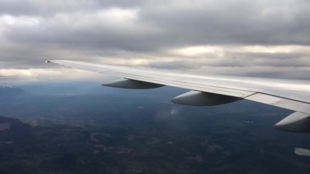 Blick durch das Fenster eines Flugzeugs, Flugzeugs oder Flugzeugflügels. Blick aus dem Flugzeugfenster bei Landung oder Start über das Stadtgebiet — Stockvideo