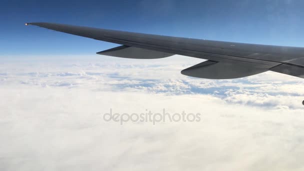 Uitzicht vanuit het raam van een vliegtuig op de vleugel en het landschap eronder. Vleugel van een vliegtuig vliegen boven de wolken — Stockvideo